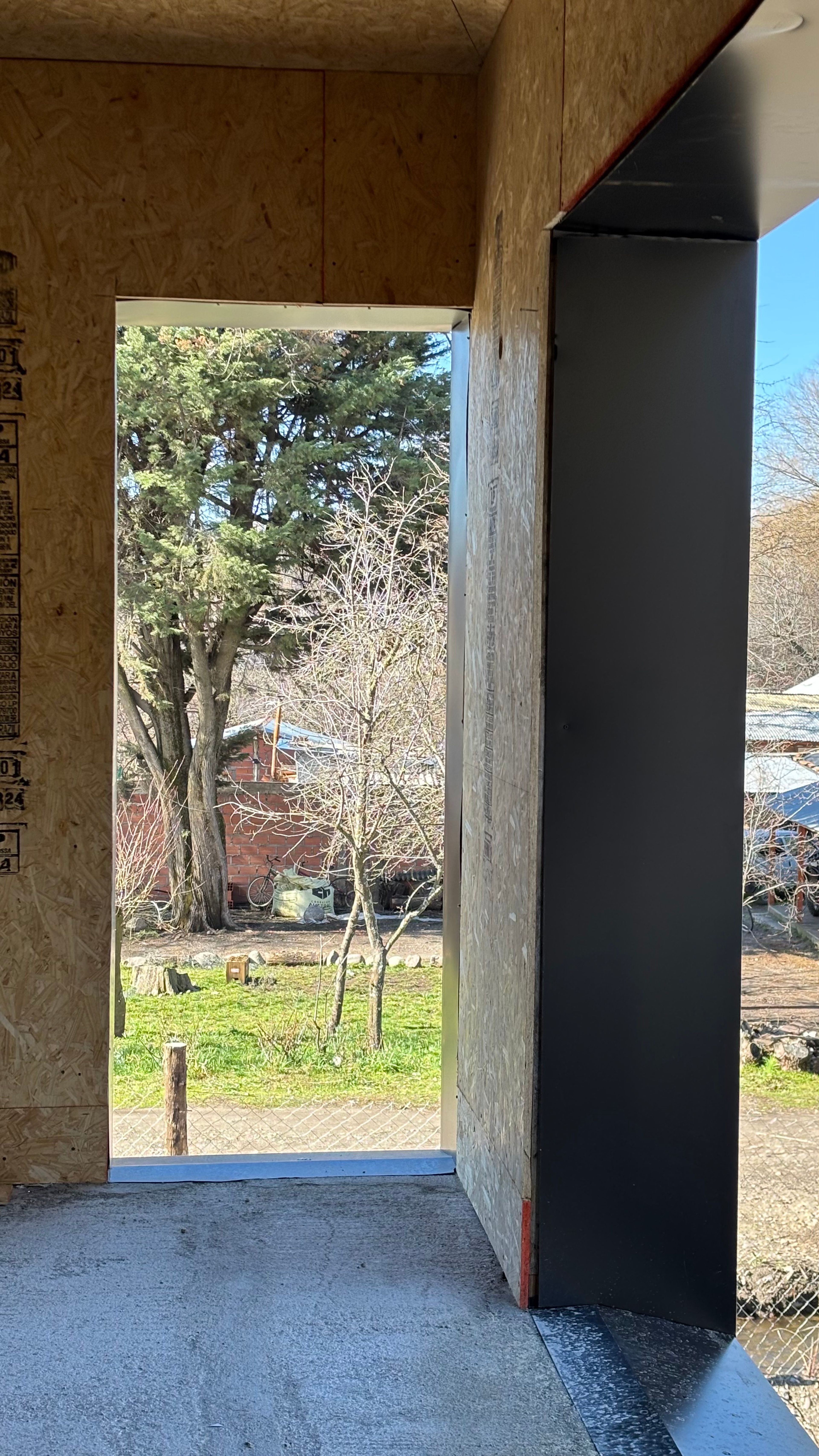 Vano de una ventana en obra en PSMA, con vista a los árboles de la vega.
