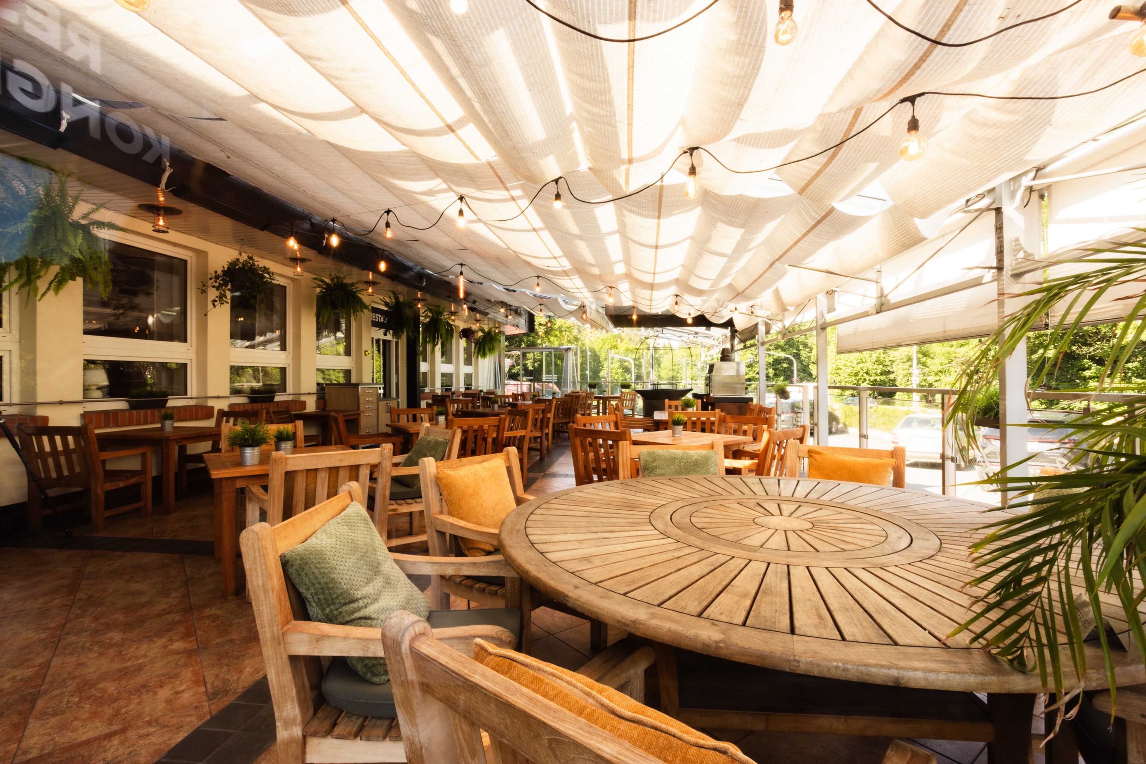 Krytá terasa restaurace s dřevěným posezením