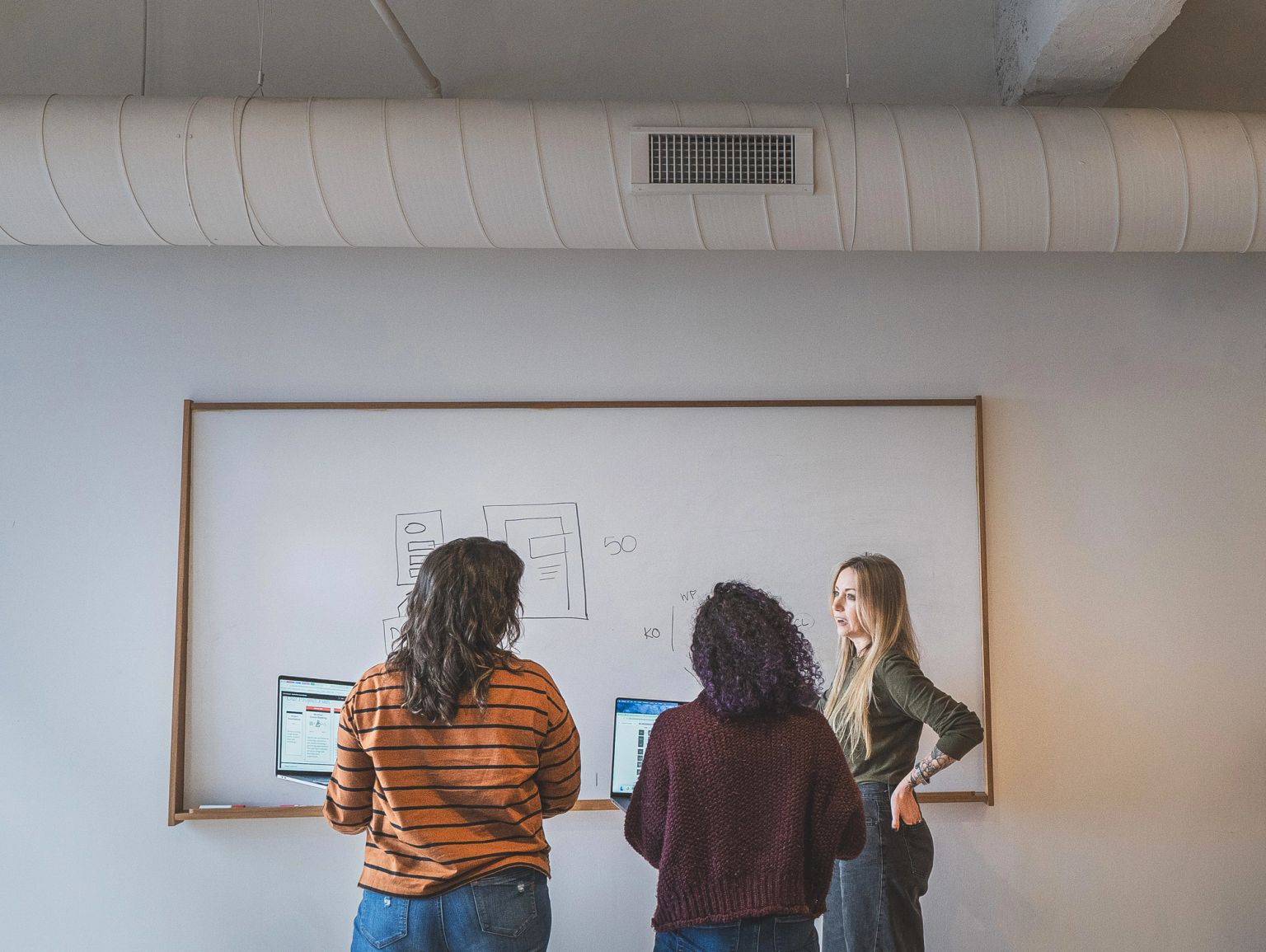 Thinkers collaborating at a white board