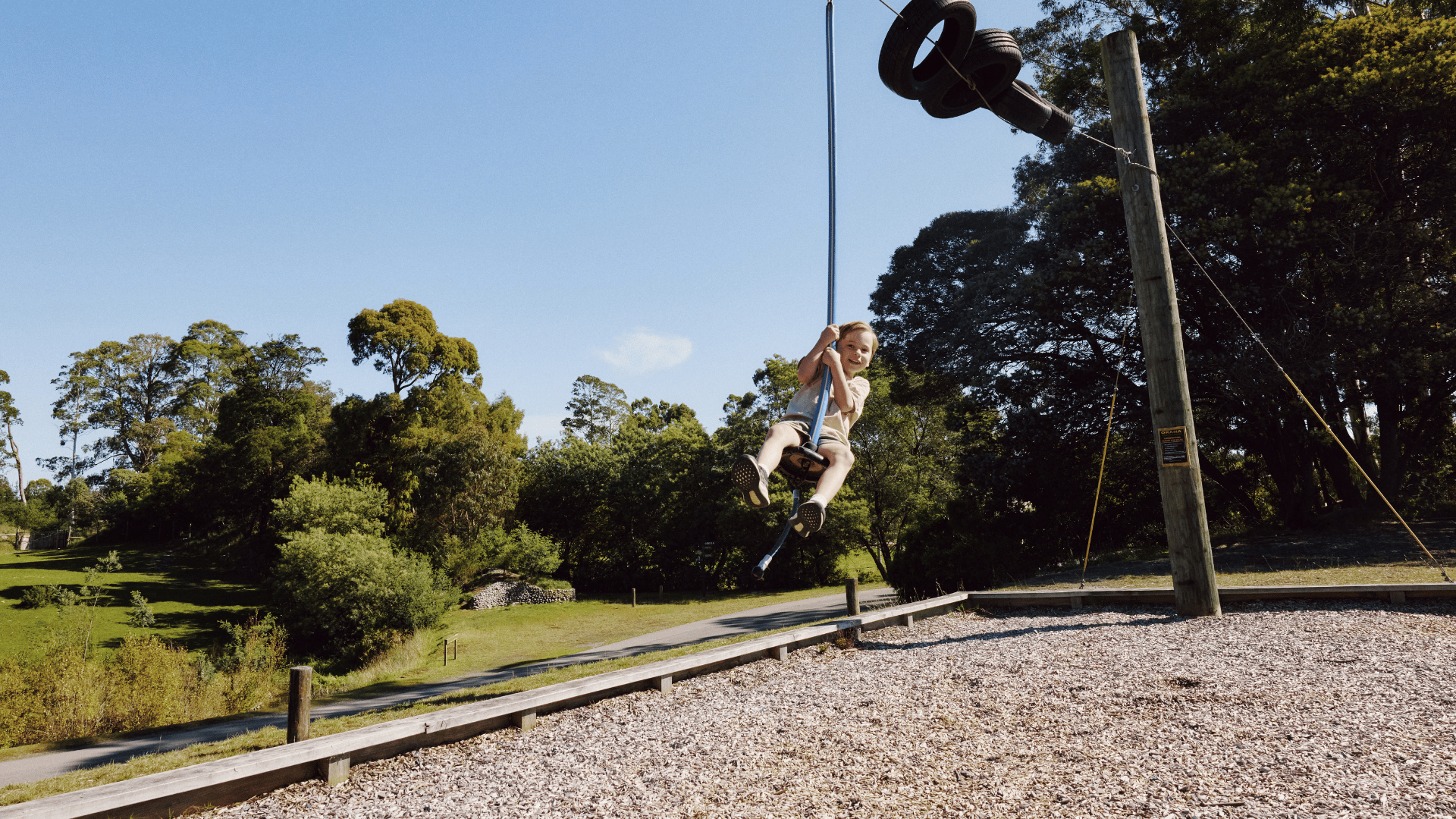 A child riding a flying fox in the playground