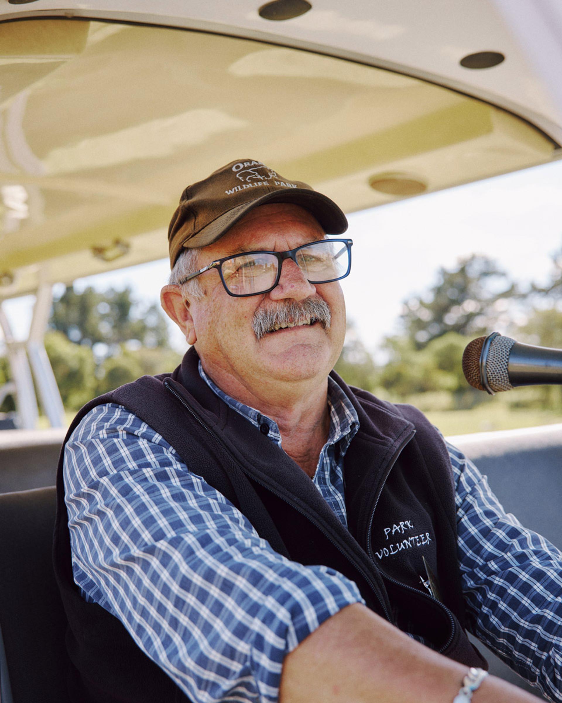 A smiling Orana volunteer driving the Park's tour shuttle