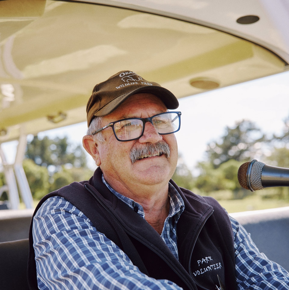 A smiling Orana volunteer driving the Park's tour shuttle