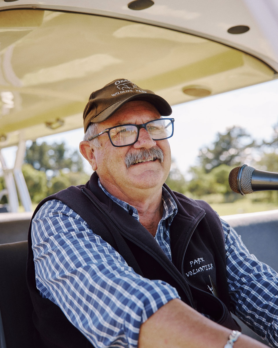 A smiling Orana volunteer driving the Park's tour shuttle