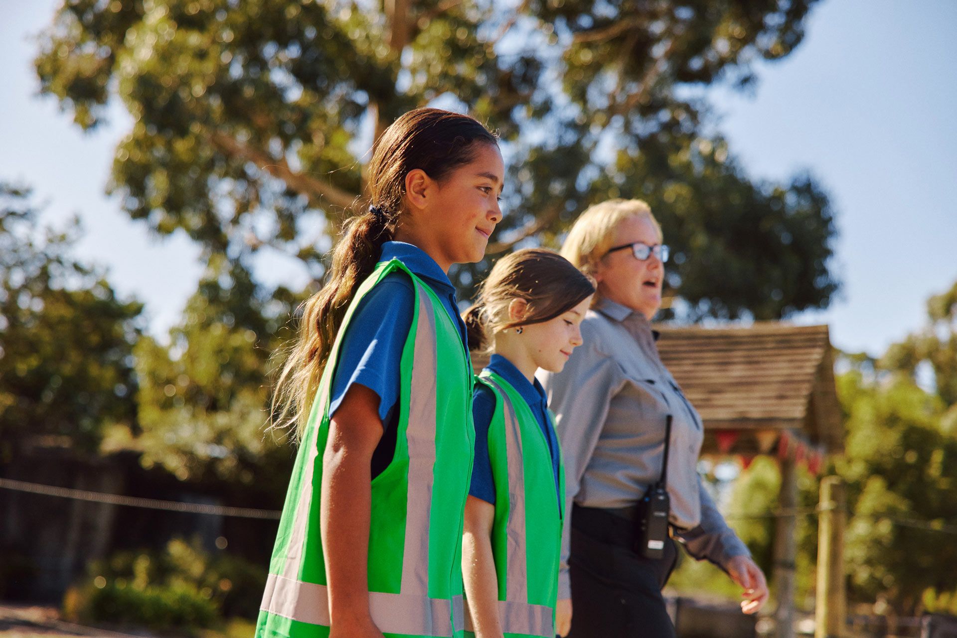 Students in hi-vis vests walking through the Park with an Orana staff member