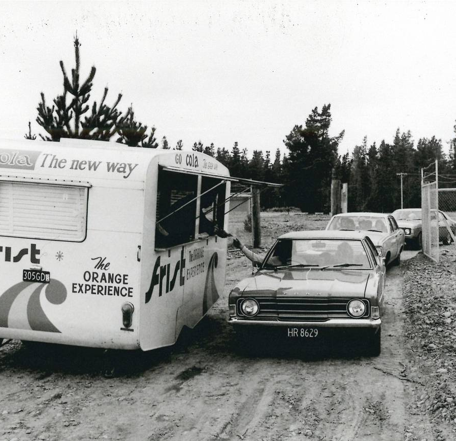 A black and white photo from opening day showing a car pulling up beside a caravan to purchase a ticket