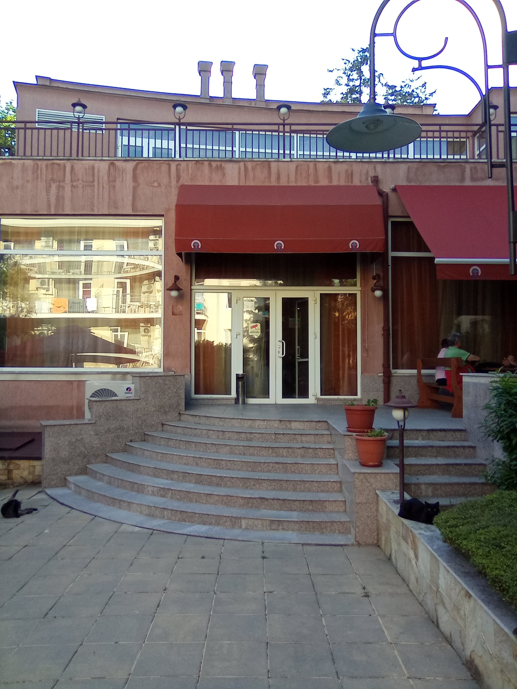 Restaurant entrance with red awnings at the top of wide stone steps