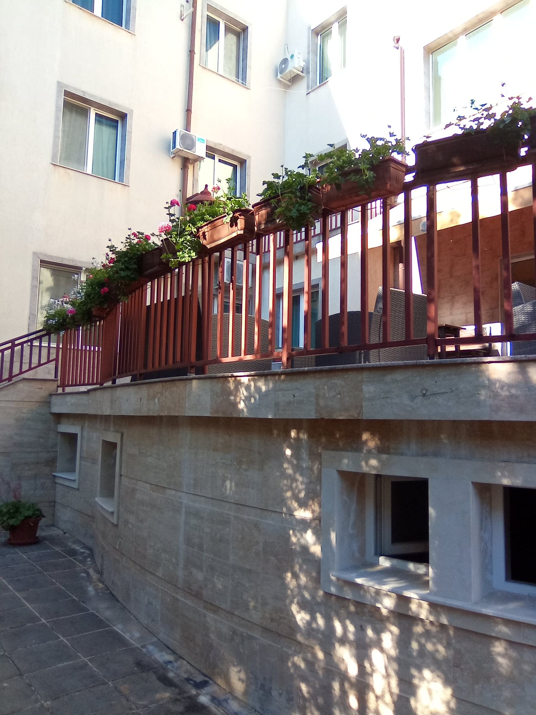 Wooden terrace railing with flower boxes above a stone wall