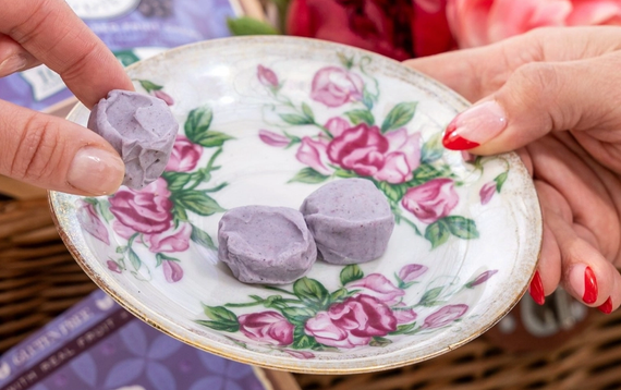 Grapes and a piece of candy on a wooden cutting board