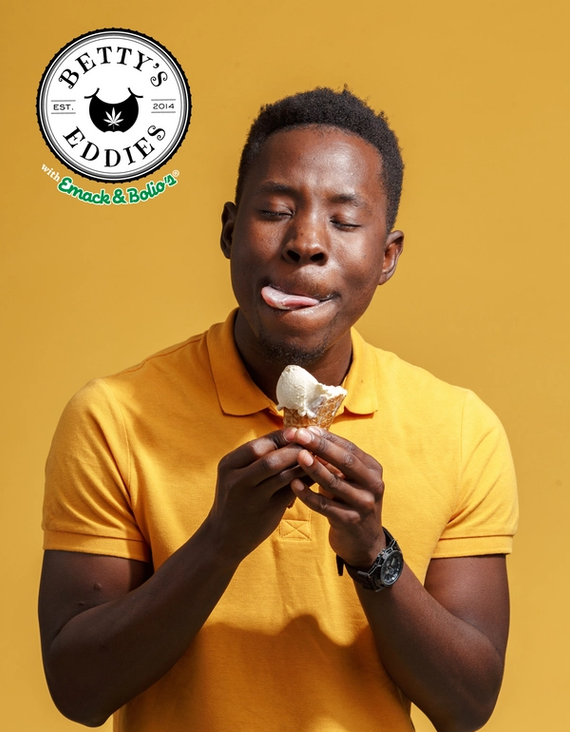 Man laughing while holding an ice cream on a yellow background