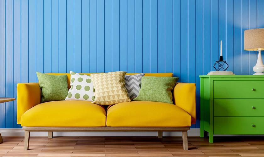 apartment with bright blue wall, yellow couch and green dresser