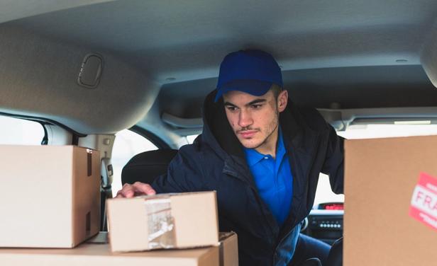 courier checks a package before delivering to package room