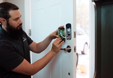 image of person installing smart lock on front door