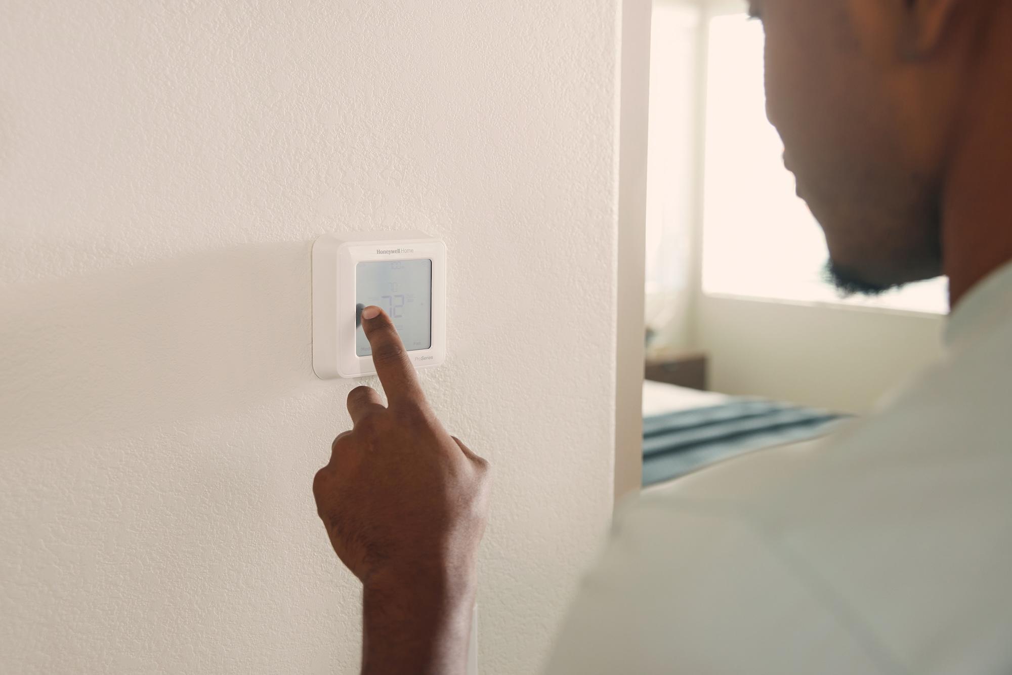 Resident adjusts a smart thermostat offered by SmartRent