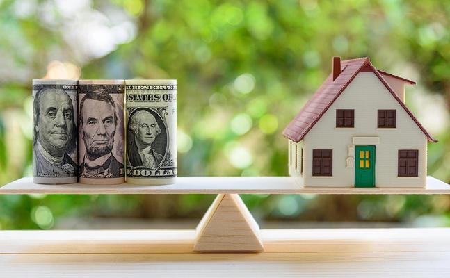 money and house balancing on teeter totter