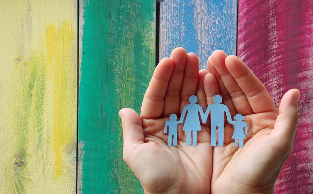 hands holding paper cutout family