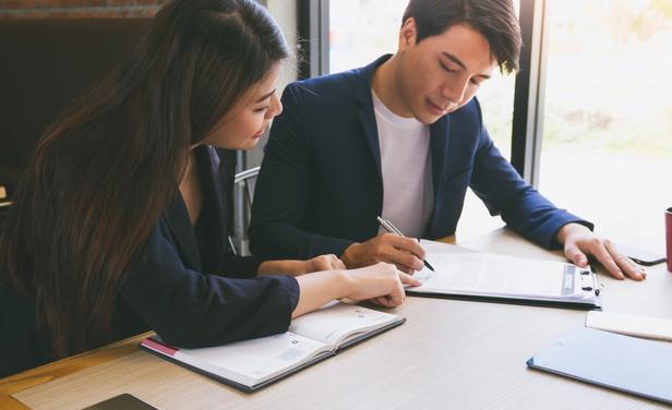 two people looking a documents on a desk together