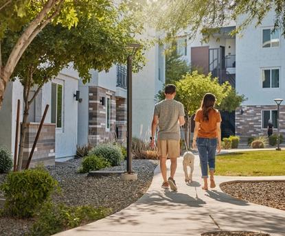 Couple walking dog in courtyard