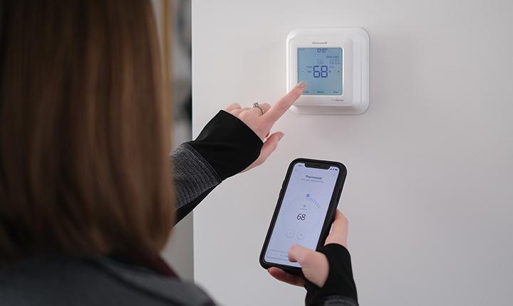 Student operating a smart thermostat