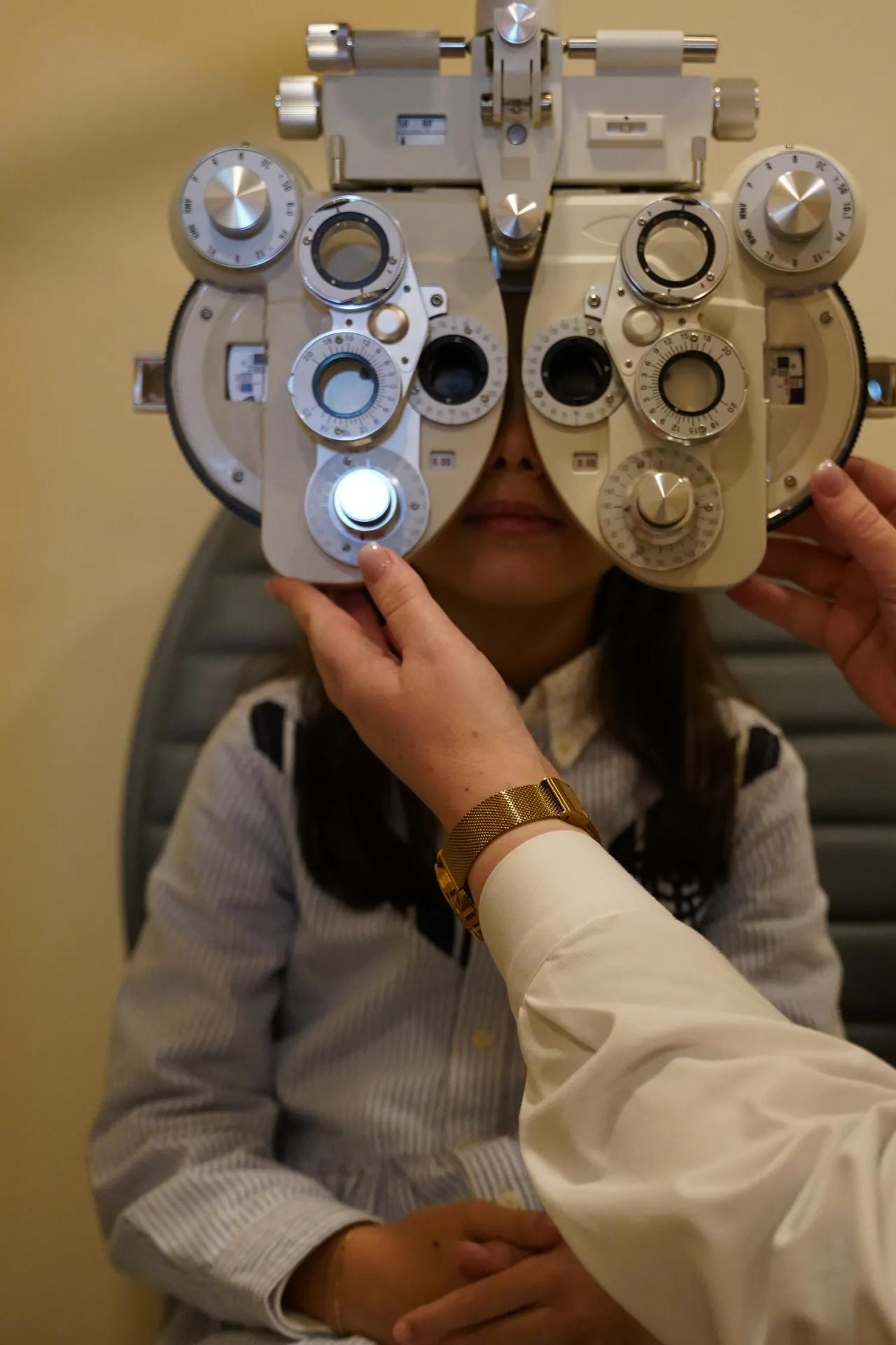 Optometrista a ajustar foróptero durante consulta