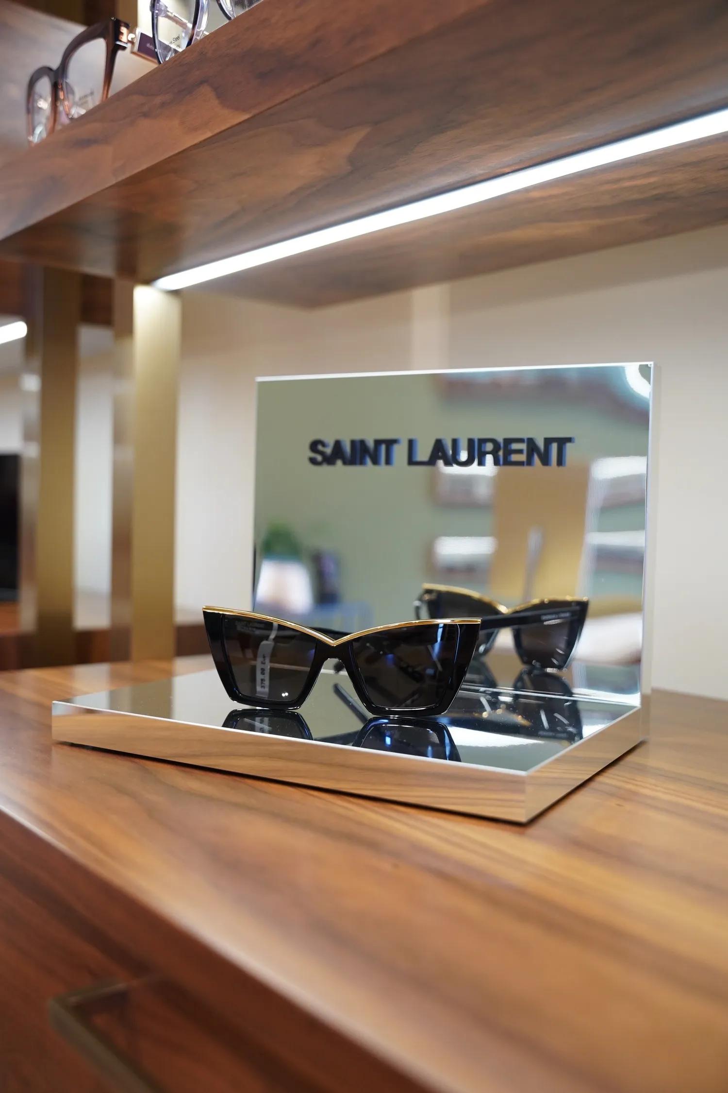 Óculos Saint Laurent cat-eye em expositor com espelhos