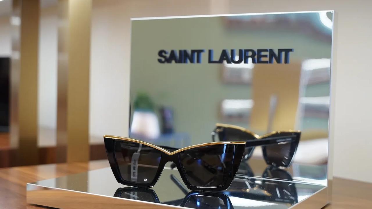 Óculos Saint Laurent cat-eye em expositor com espelhos