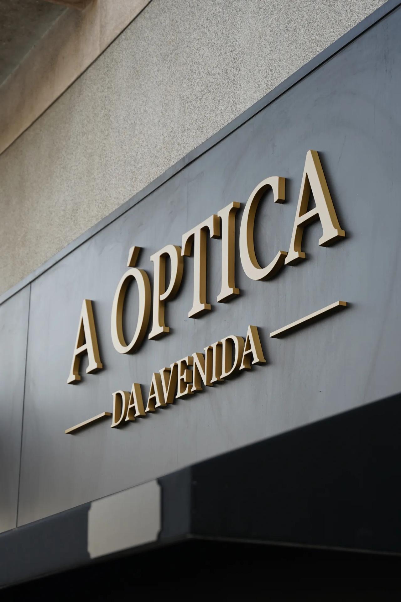 Letras douradas A ÓPTICA DA AVENIDA na fachada escura