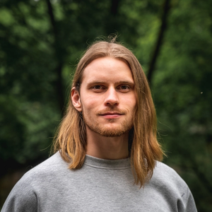 Portrait of Glenn with long hair and a gray sweater