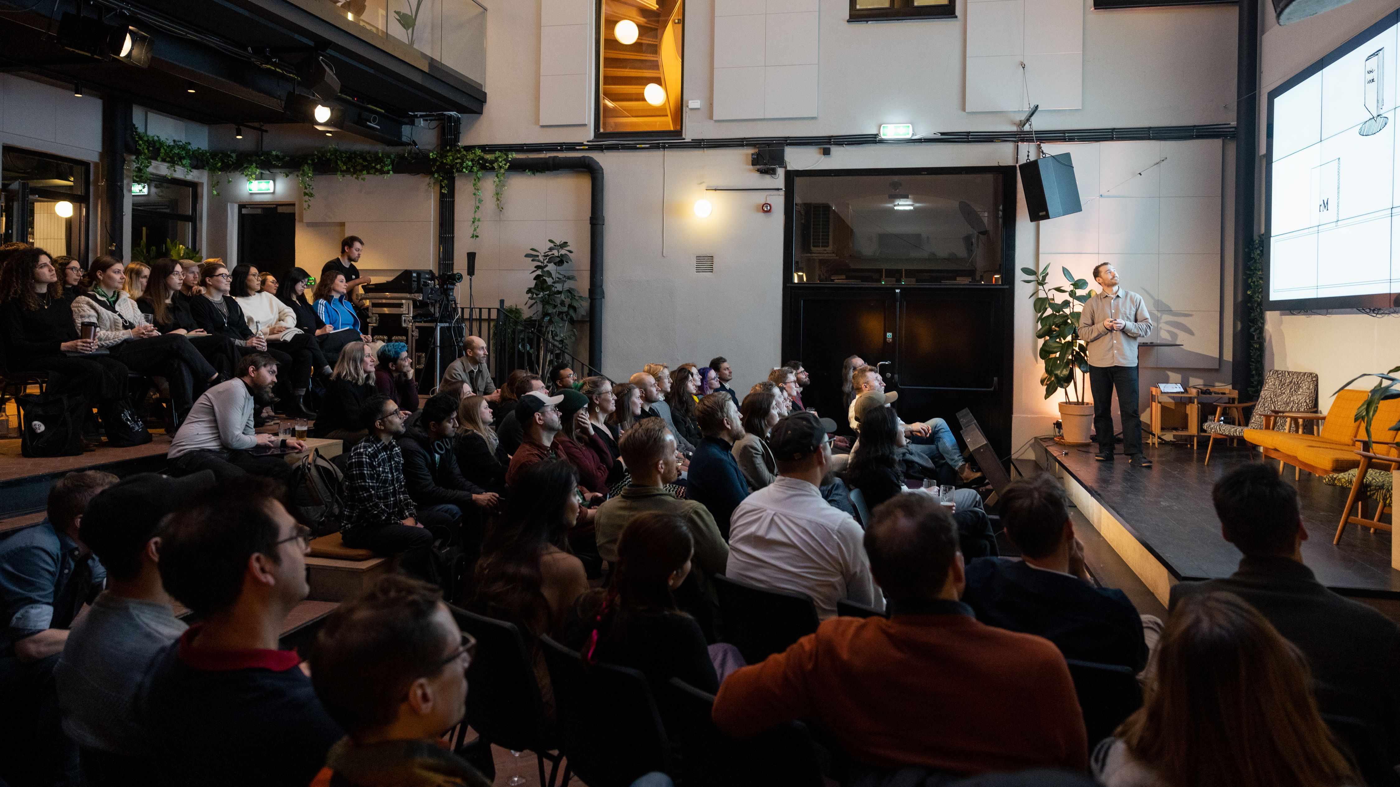 Stian Surén of reMarkable onstage at IxDA Oslo's meetup Nº 149, in the Atrium at MESH Youngstorget