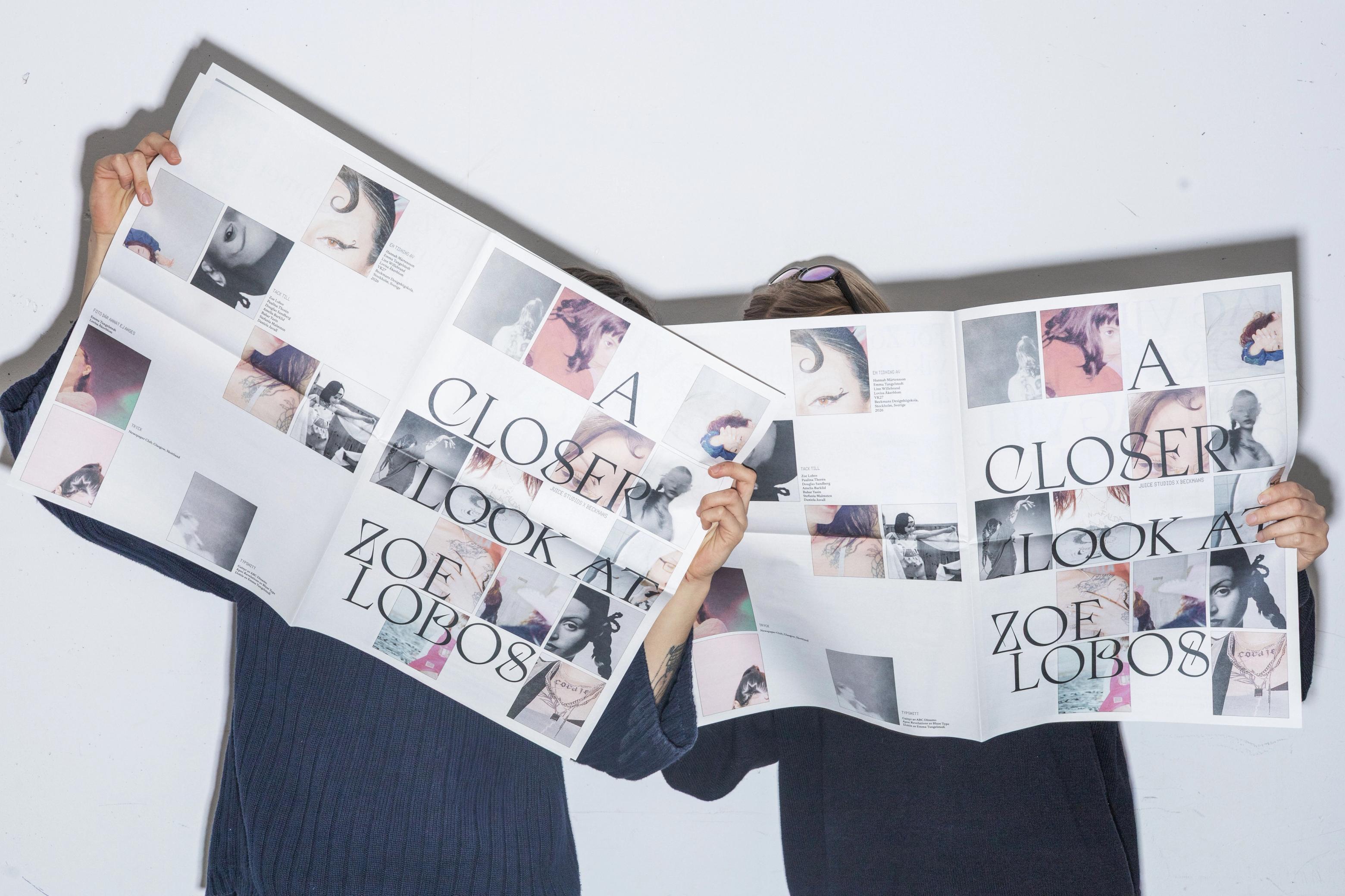 Två personer håller upp uppslagna tidningar framför ansiktena med rubriken "A Closer Look at Zoe Lobos" och fotografier.