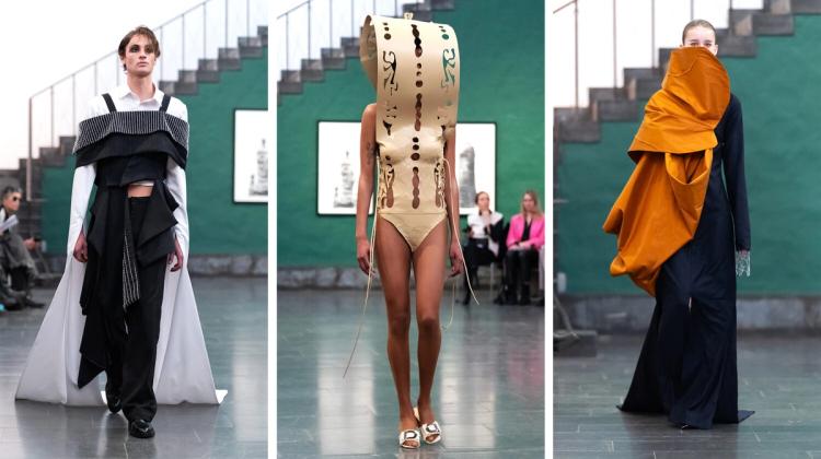 Tre modeller på catwalk: en i svartvit lagerlook, en i beige utskuren skulptur som täcker huvud och överkropp, en i mörkblått med orange draperi.