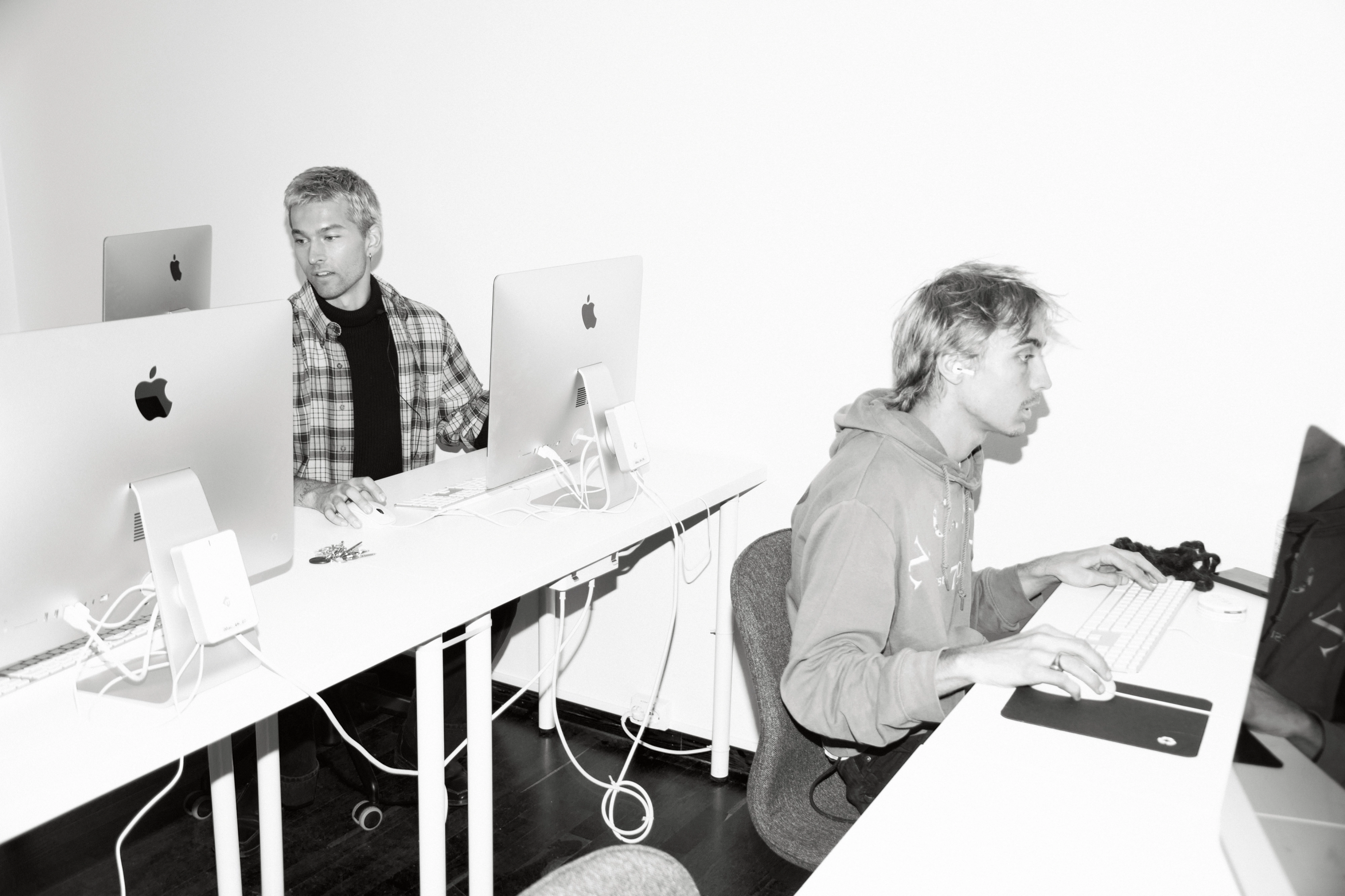 Svartvitt: två personer arbetar vid stationära datorer i en datorsal.