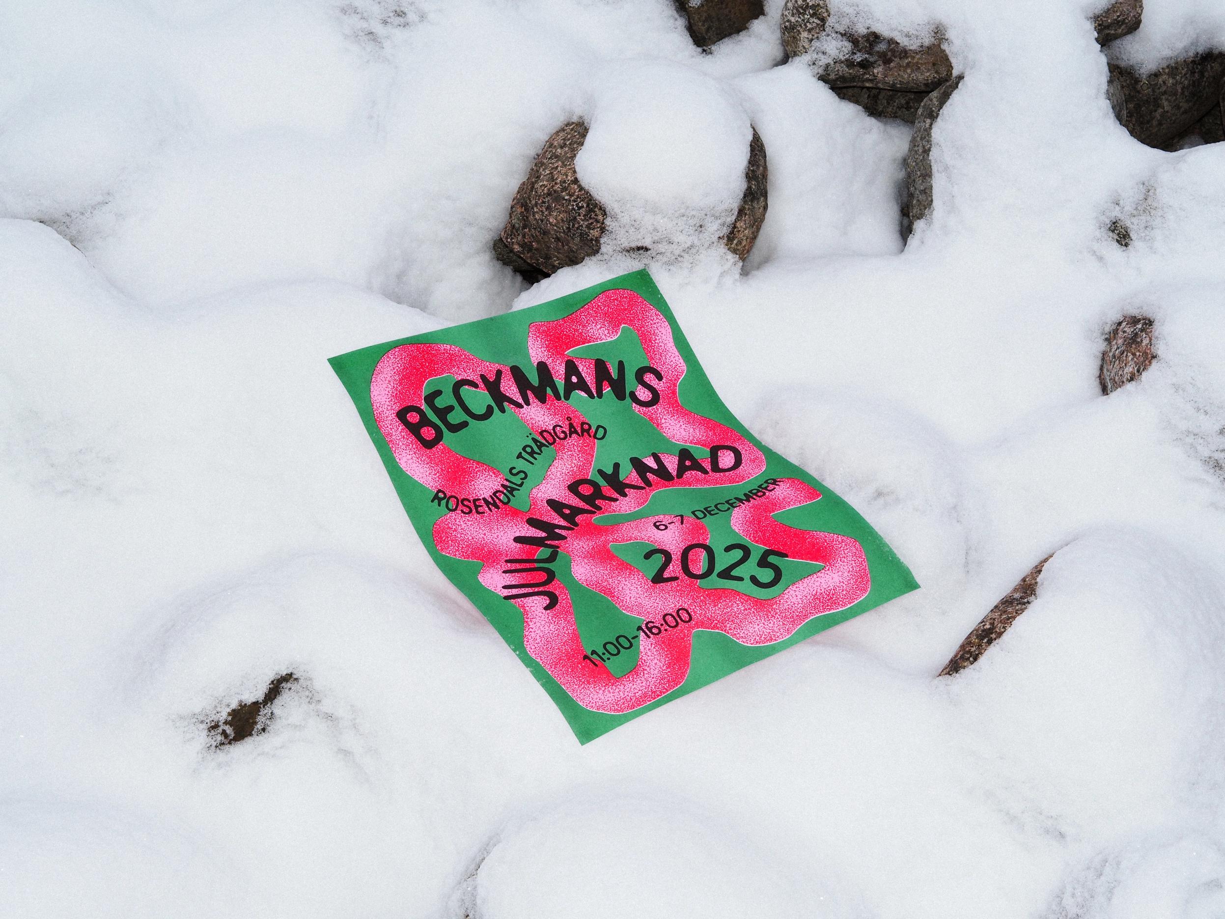 Grön och rosa affisch för Beckmans julmarknad 2025, Rosendals trädgård, 6–7 december, kl. 11–16, liggande i snön.