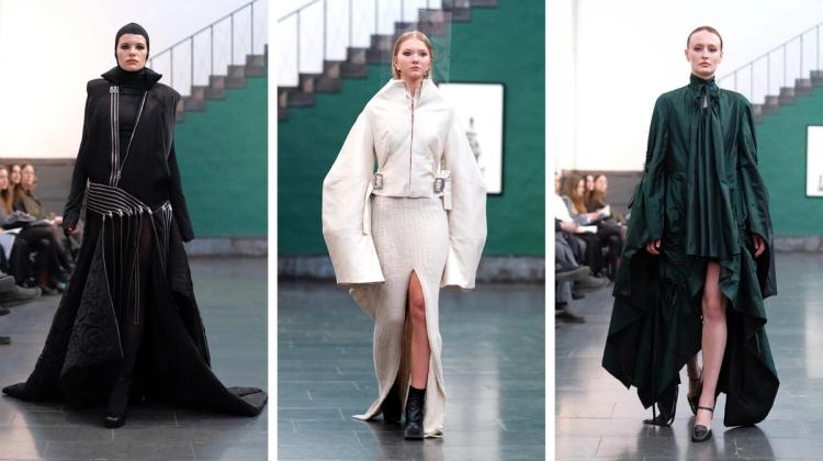 Tre modeller på catwalk: en i svart huva och lång kappa med dragkedjor, en i vit jacka och stickad kjol med slits, en i mörkgrön draperad klänning.