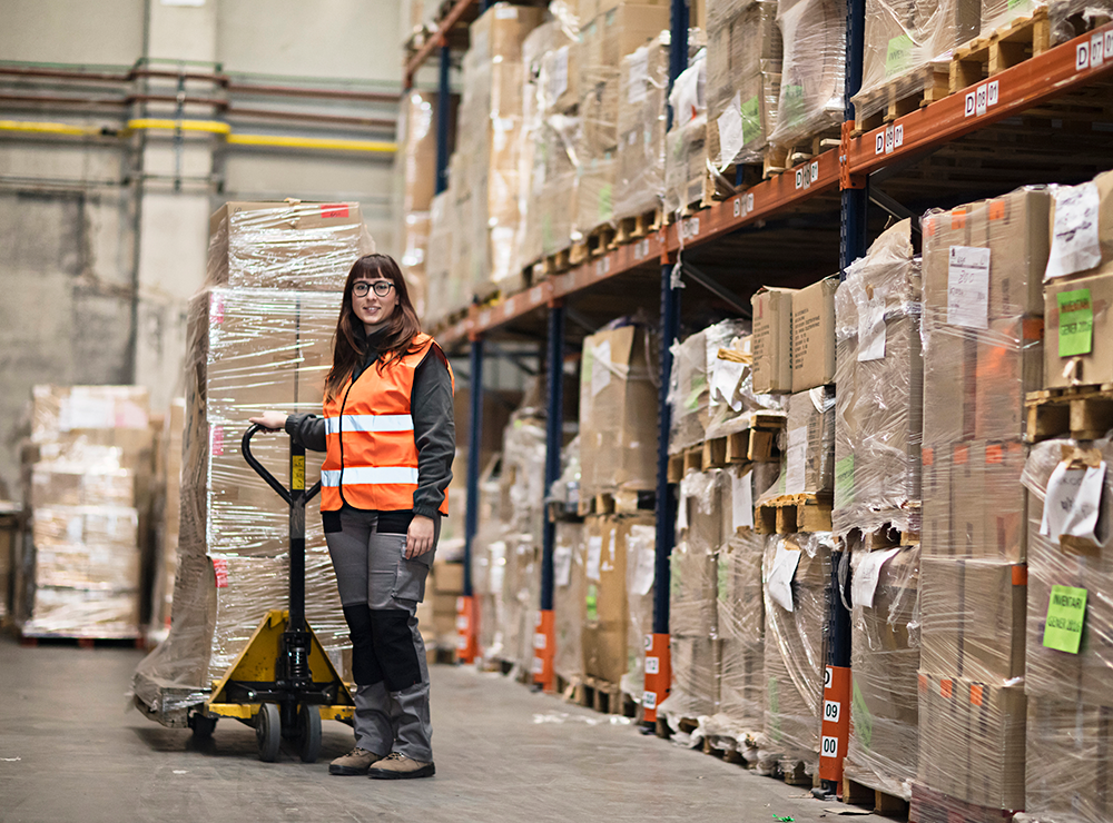 woman with pallet of goods in a warehouse