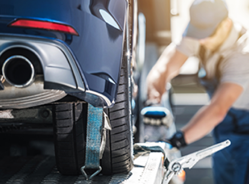 Man securing car on transport truck