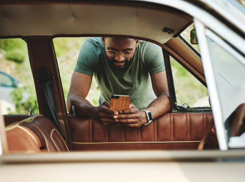 man with phone looking at car