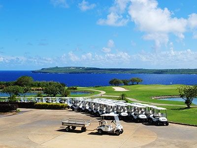 Row of golf carts at a golf course near water