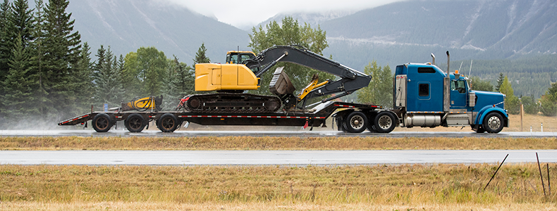 heavy equipment being hauled on a flatbed trailer