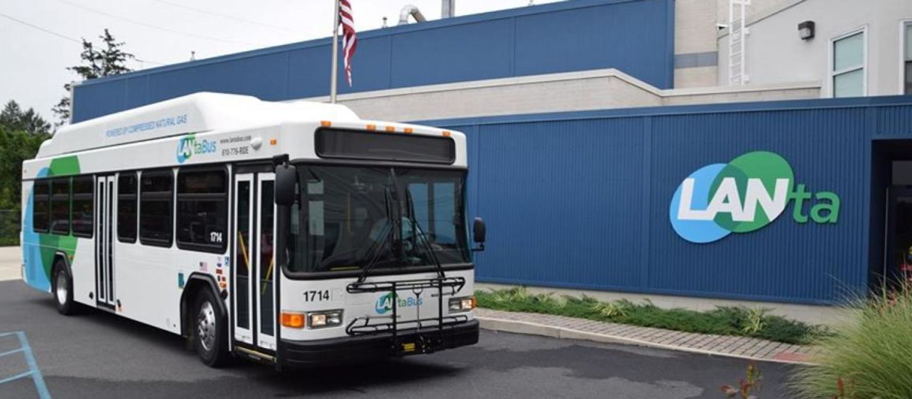 A Lanta bus is parked next to the Lanta building headquarters.