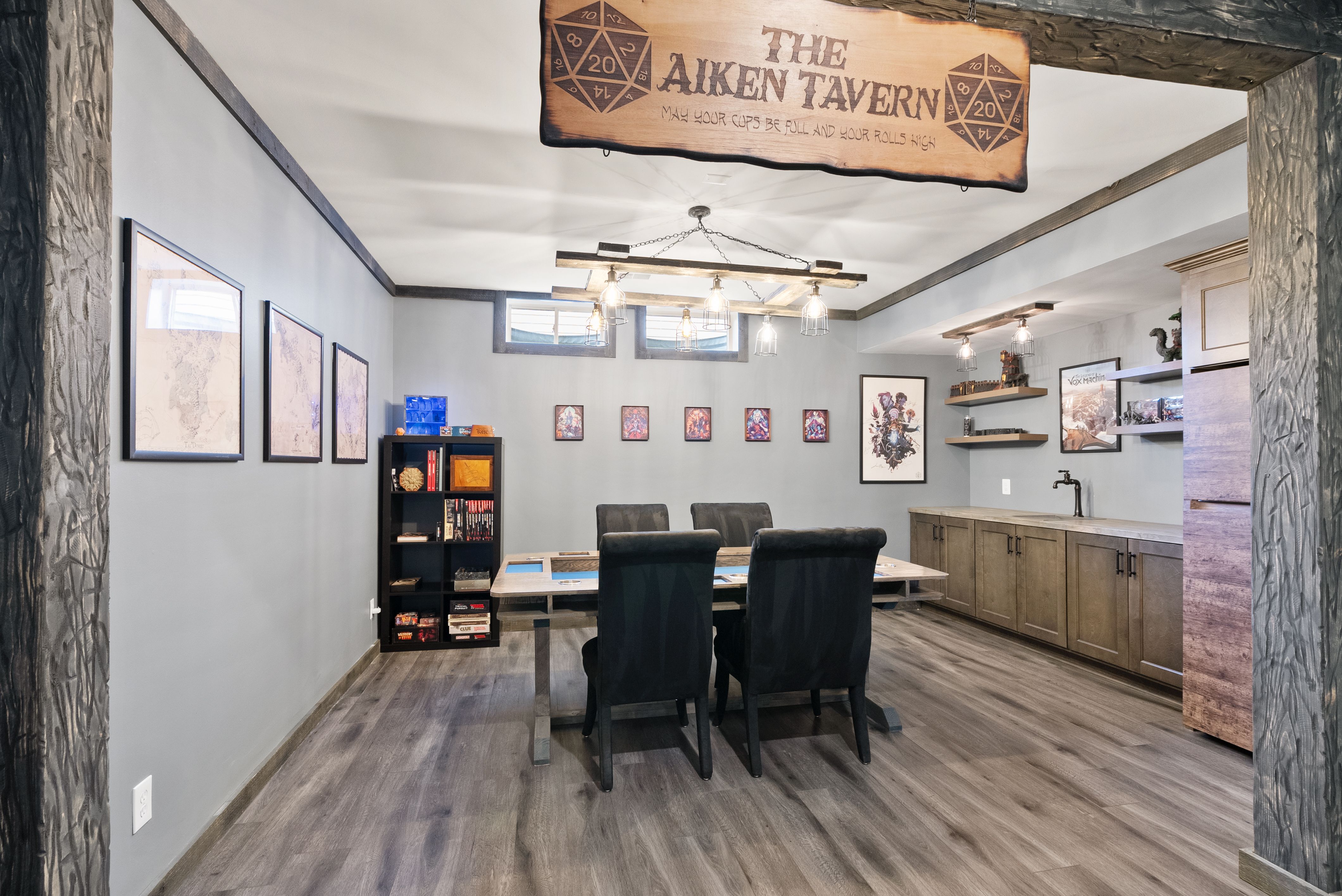 Stylish remodeled basement with wet bar and game room in Lorton, VA featuring gray cabinetry, custom shelving, and modern lighting fixtures.
