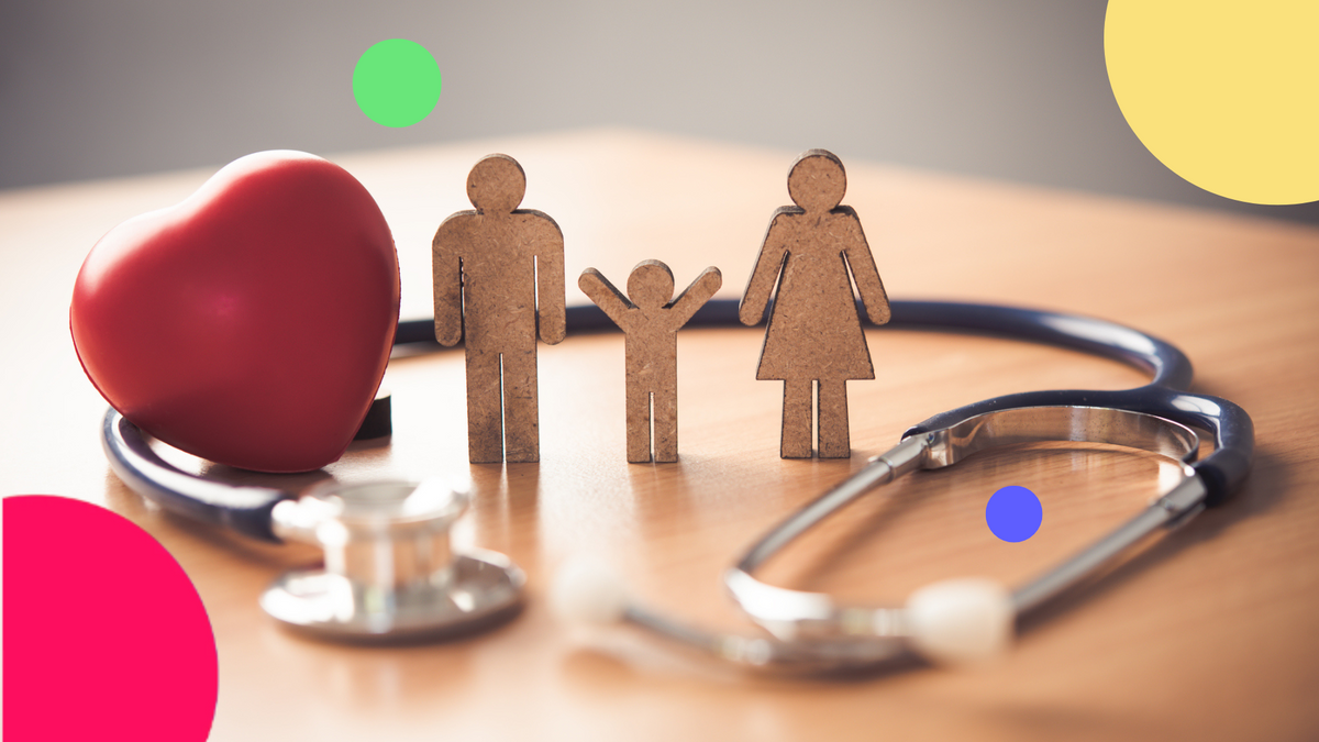 A hand stacking coins on top of a wooden block with a heart on it