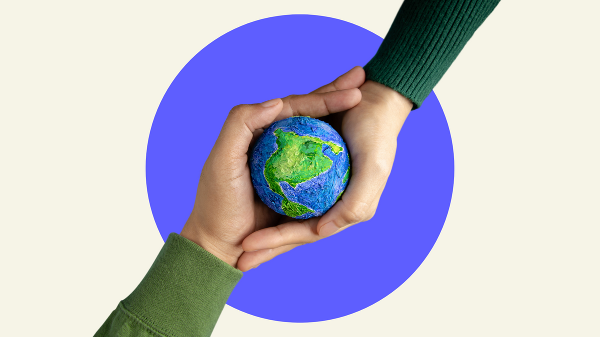 Two pairs of hands holding a model of planet Earth