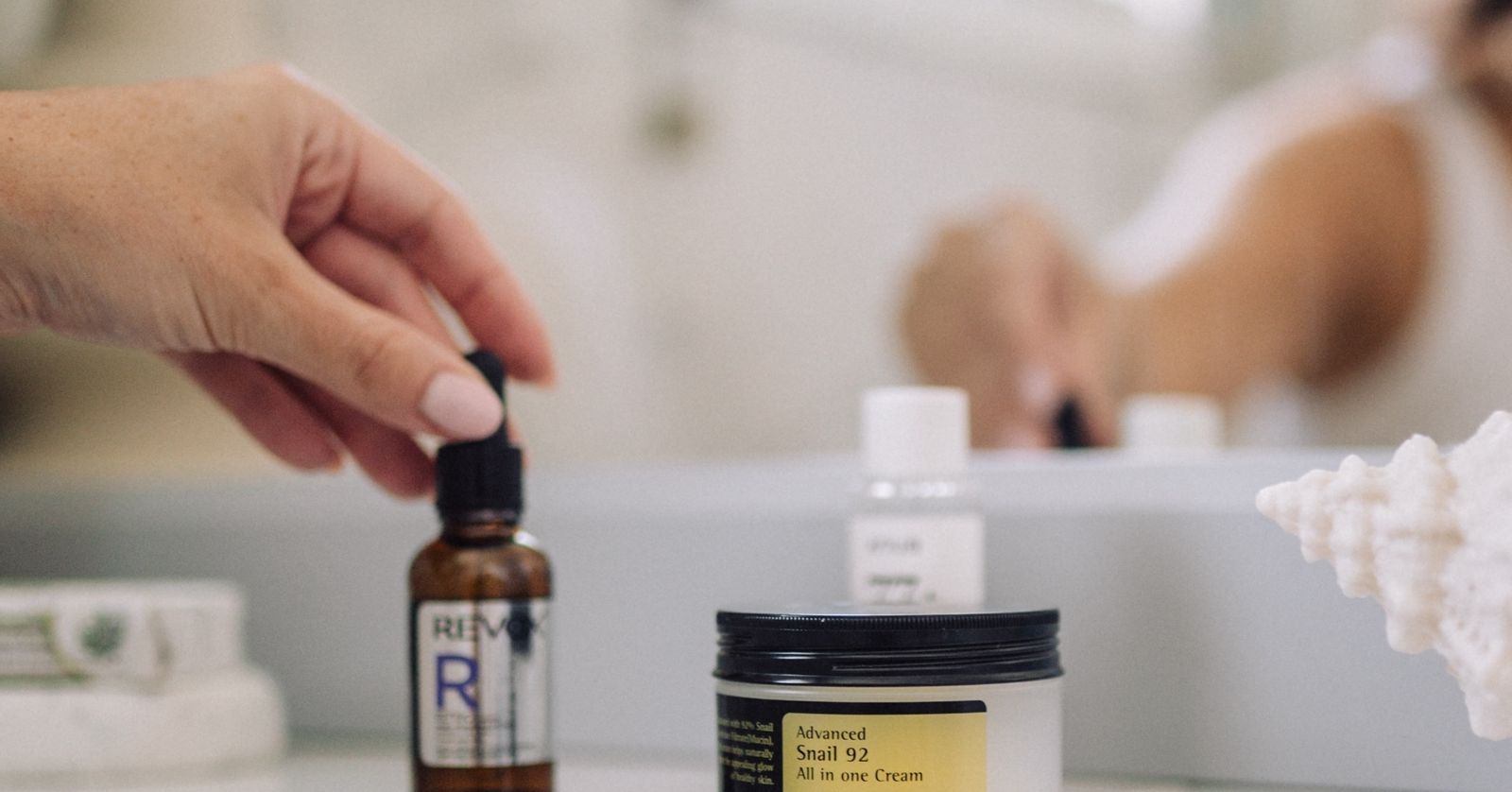 Koupelnová scéna s produkty péče o pleť Corsx a Revox