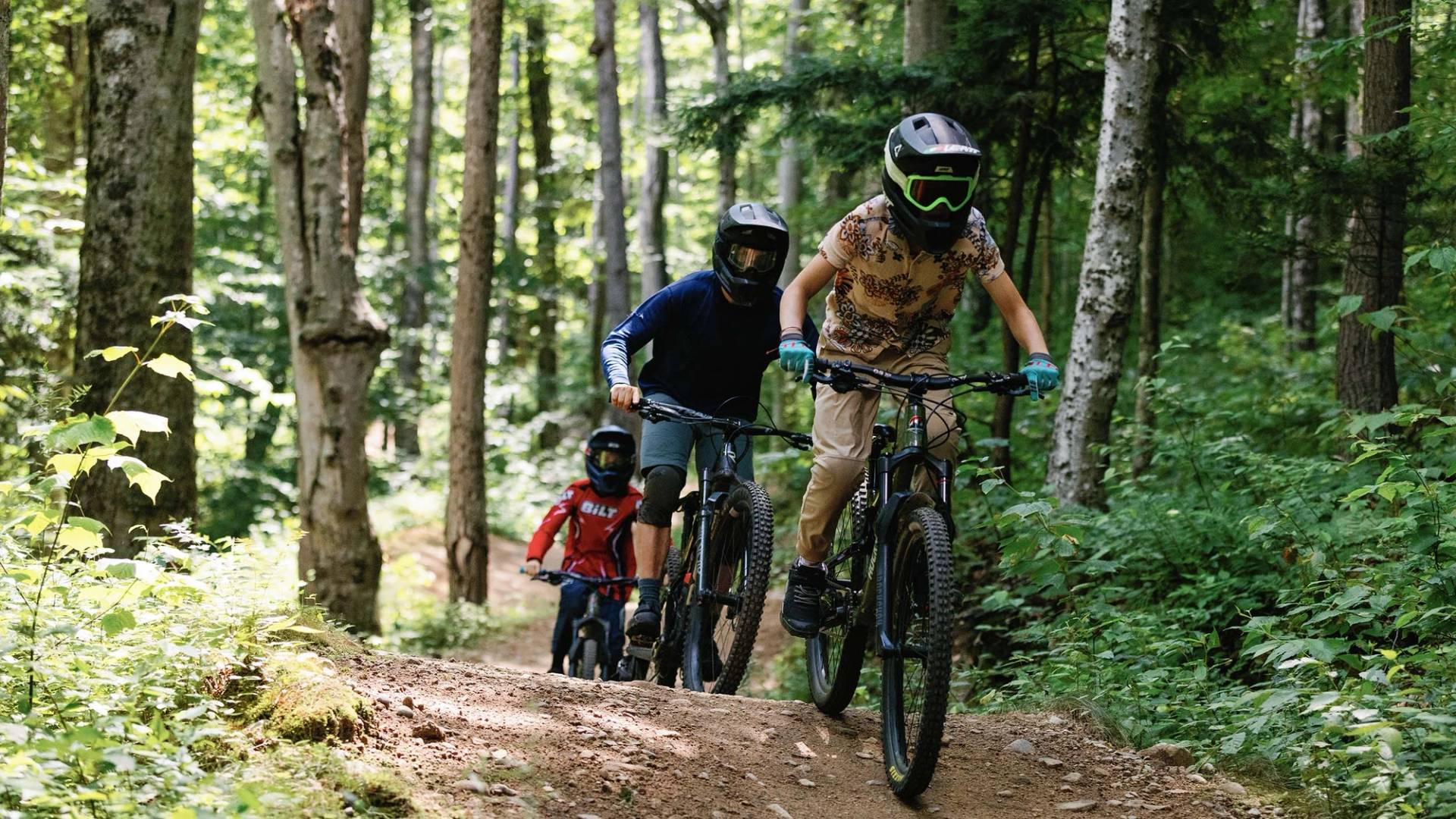Group of bike campers riding a downhill mountain bike trail