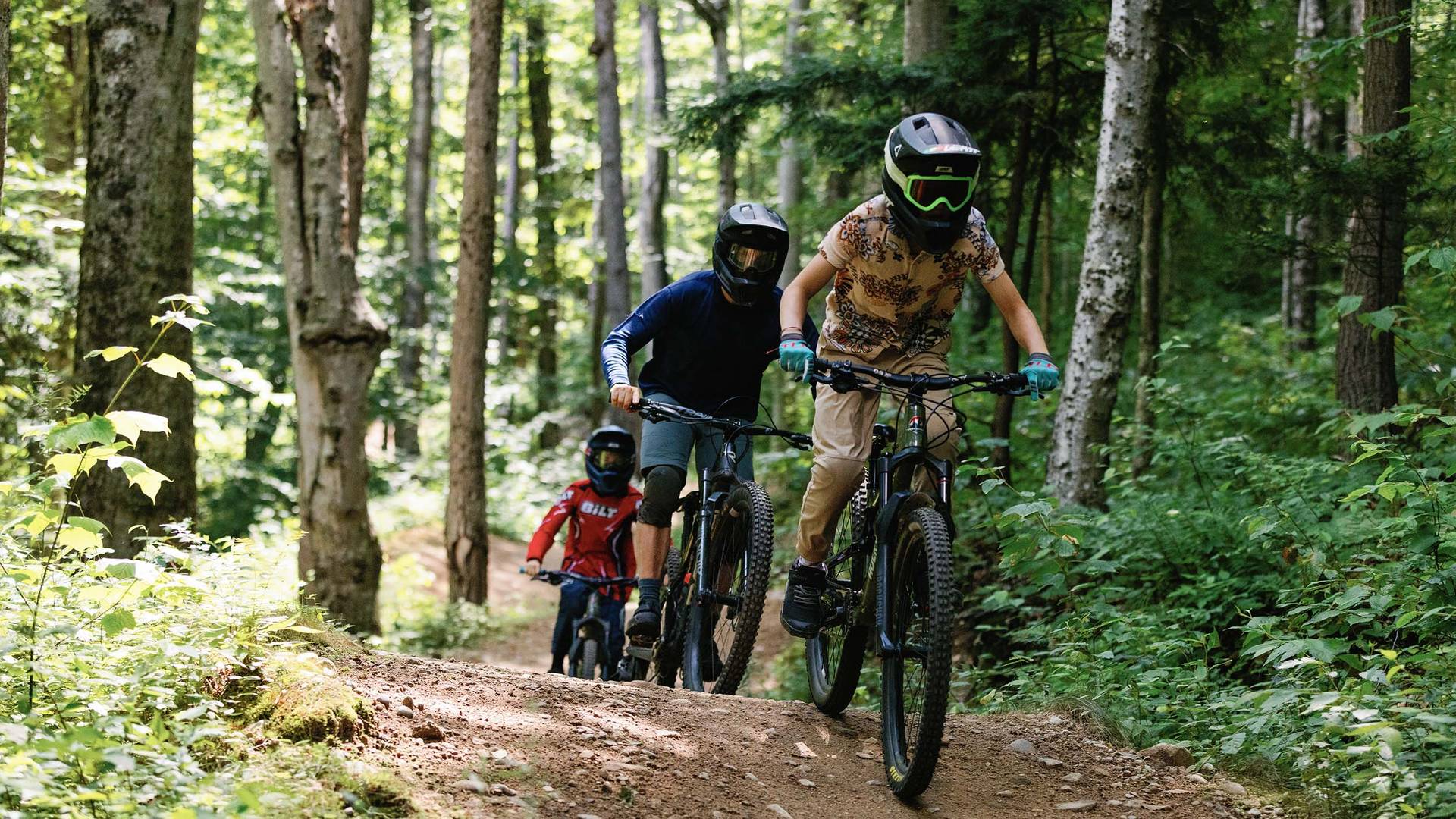 Group of bike campers riding a downhill mountain bike trail