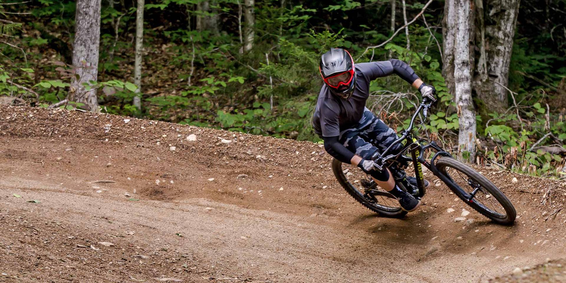 Downhill mountain biker riding a berm in Loon Bike Park