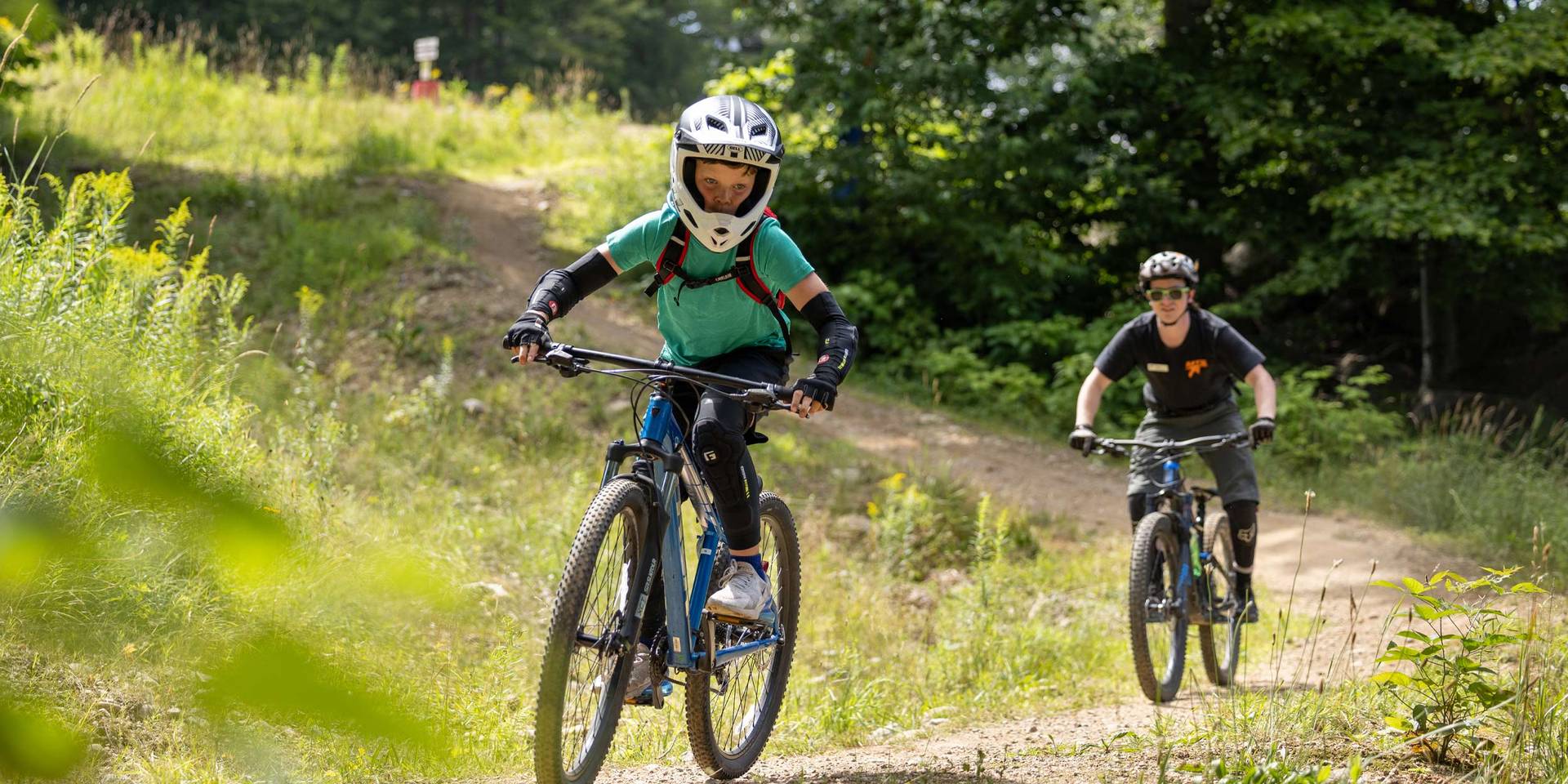 two bikers on a downhill trail