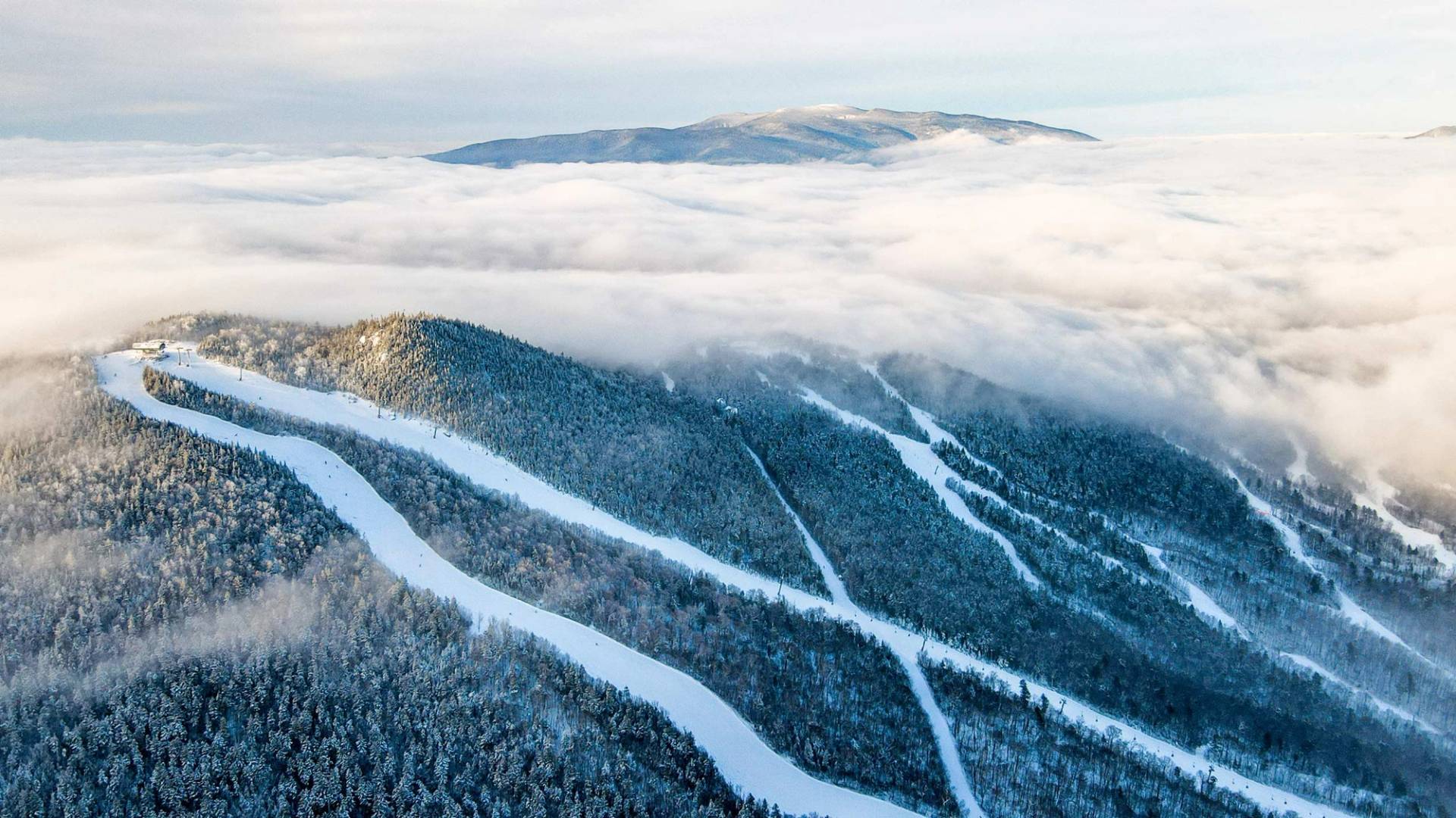 Winter drone shot of Loon Mountain, with summit enshrouded in clouds