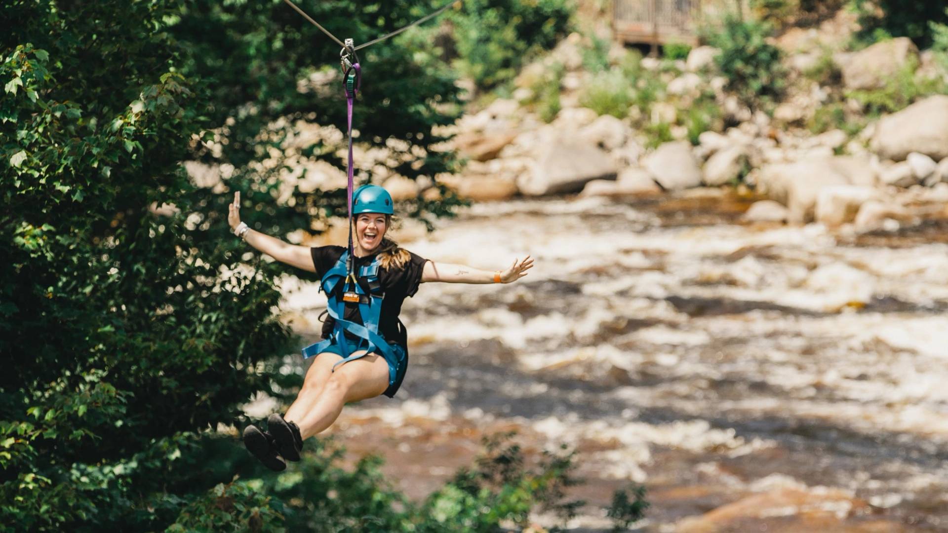 girl ziplining across the river