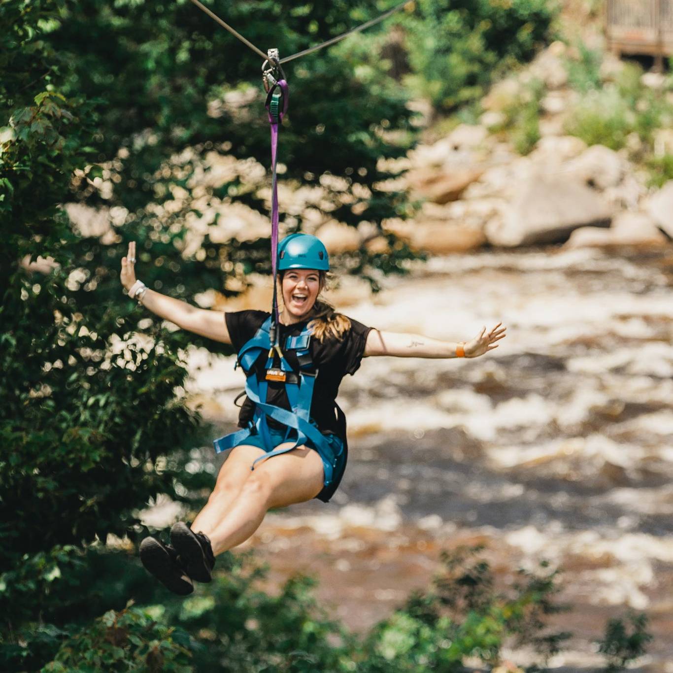girl ziplining over river